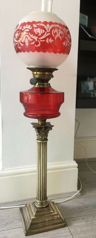 Large Oil Lamp With Blood Red Glass Fount,  Brass Corinthian Base And Red Shade