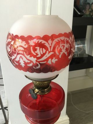 large oil lamp with blood red glass fount,  brass corinthian base and red shade 4