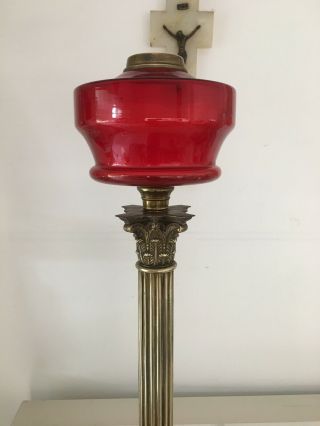large oil lamp with blood red glass fount,  brass corinthian base and red shade 6