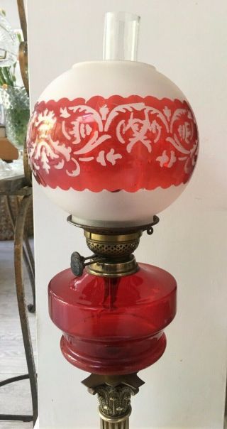 large oil lamp with blood red glass fount,  brass corinthian base and red shade 8
