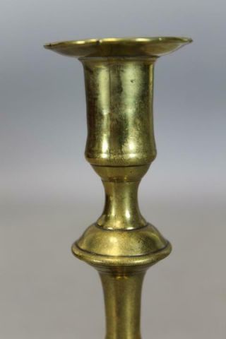 AN EARLY 18TH C ENGLISH QA BRASS CANDLESTICK BALUSTER FORM GREAT PETAL BASE 10