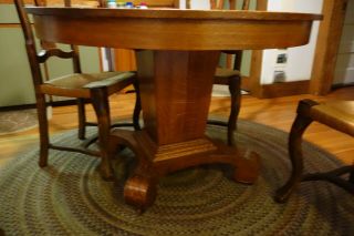 Antique oak pedestal dining table and B.  Altman rushed dining chairs 3