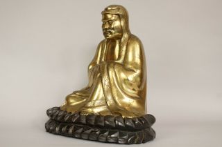 A Chinese bronze gilt figure of Bodhidharma Daruma Arhat,  wood stand 19th/20thc 3