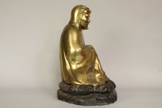 A Chinese bronze gilt figure of Bodhidharma Daruma Arhat,  wood stand 19th/20thc 8