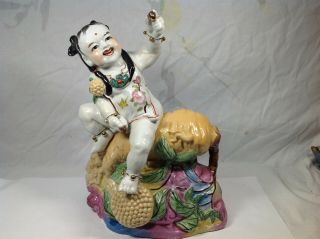 Chinese Famille Rose Figure Of Boy Seated On Gingsen Root