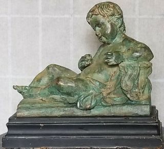 Antique French Cast Metal Statue Of A Reclining Putto On Wooden Base