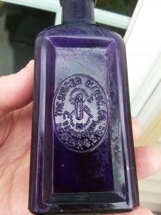 DEEP PURPLE SINGER SEWING MACHINE OIL BOTTLE NEEDLE & THREAD GRAPHIC EARLY 1900s 2