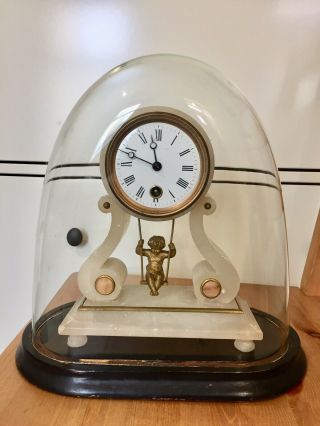 Antique Swinging Cherub Clock Under Glass Dome.
