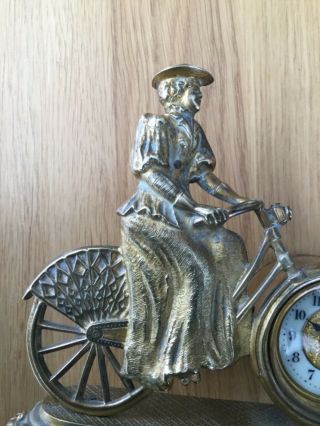 Lady on bicycle by British united.  Clock co.  Ltd. 7