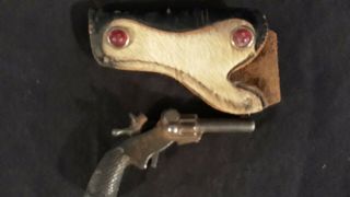 100 year old cast Iron Pluck Cap Gun.  Cow hair holster perfectly. 3