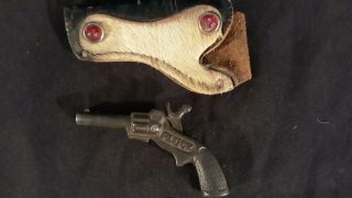 100 year old cast Iron Pluck Cap Gun.  Cow hair holster perfectly. 4