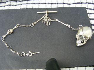 A Solid Silver Opening Pill Box Skull,  Boned Chain With A Watch Winder And Fob.