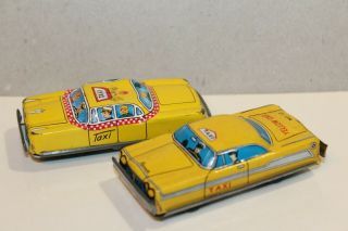 Two Vintage Tin Litho Friction Powered Plymouth Yellow & Checker Taxi Cabs