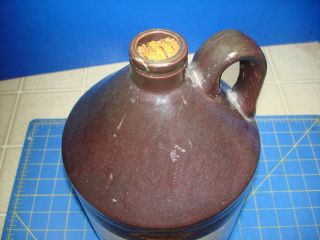 1 GALLON BROWN AND BEIGE STONEWARE JUG AND DISPLAY 5